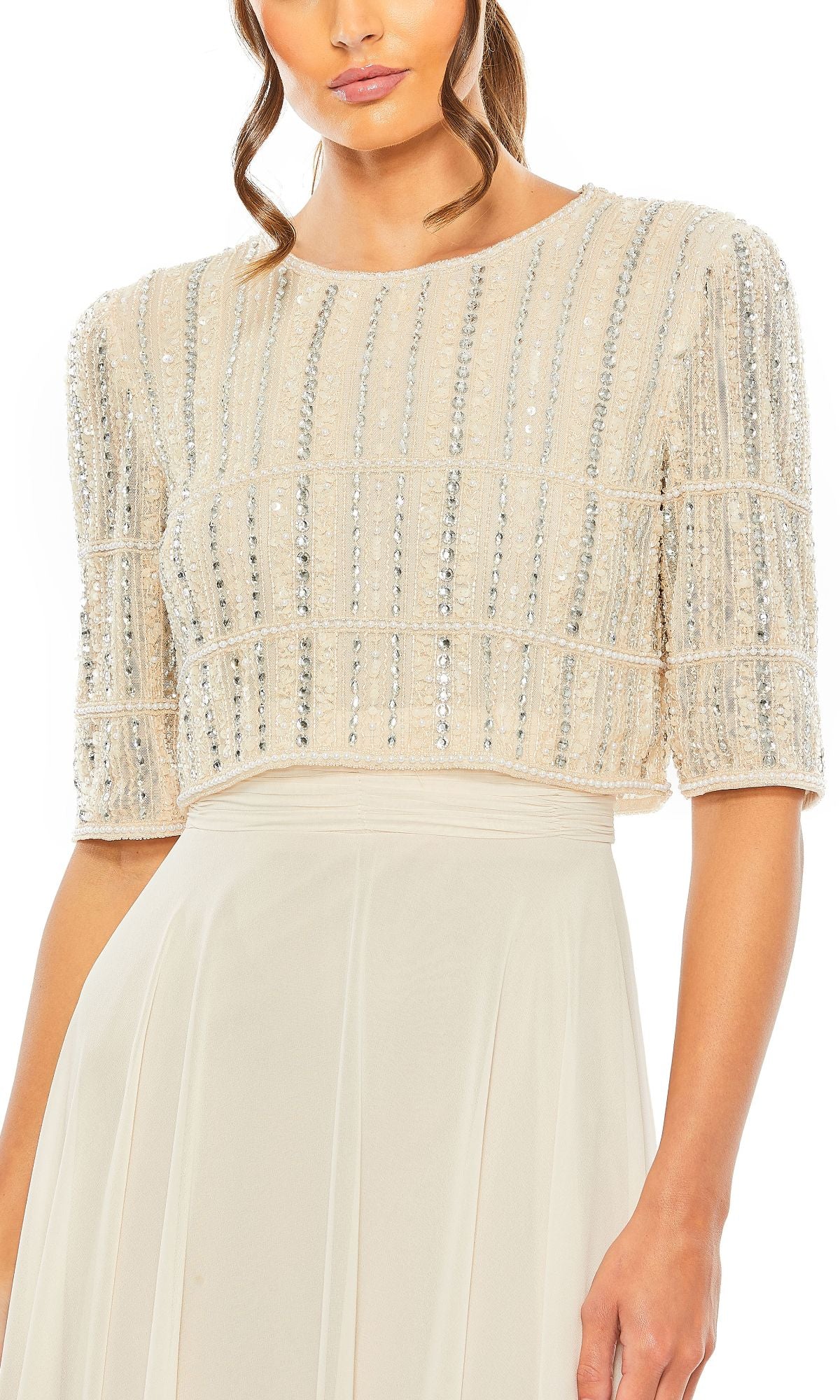 A woman wears the Mac Duggal 9180, a short-sleeve long formal dress in cream with vertical sequin embellishments for a chic evening look.